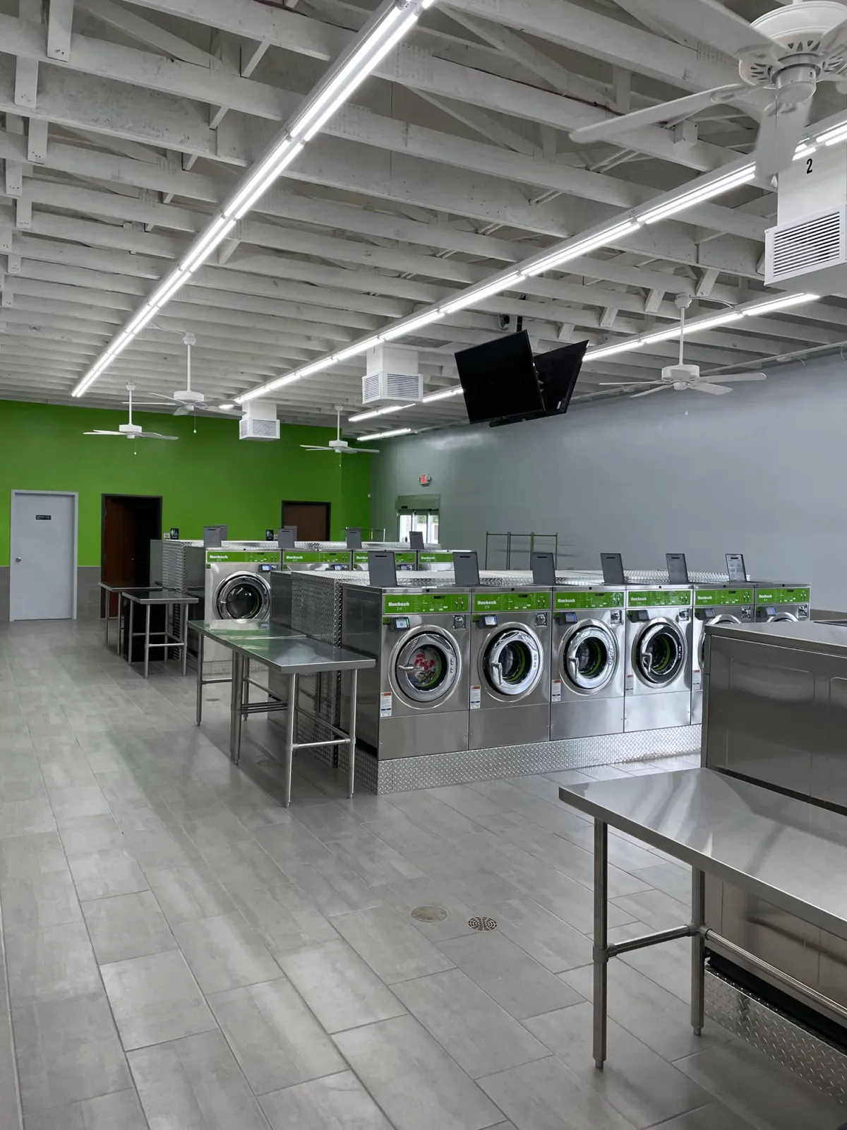 Inside Coin Laundry Co — commercial Huebsch washers and stainless steel folding tables